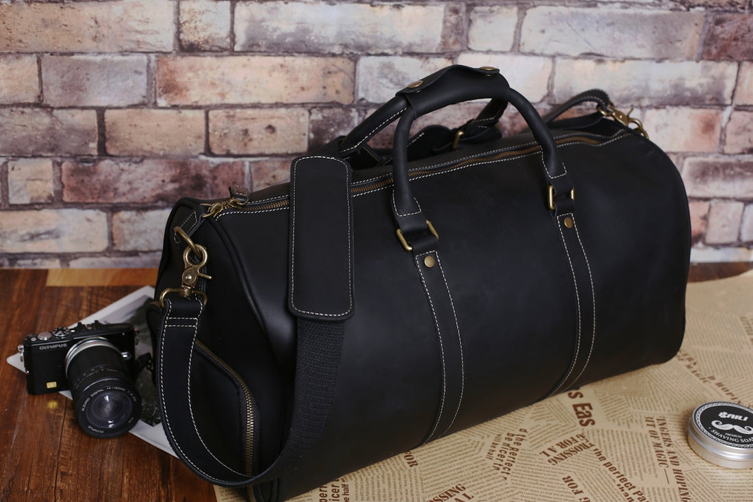 a black leather duffel bag sitting on top of a table